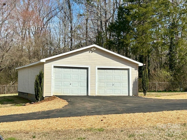 detached garage featuring fence