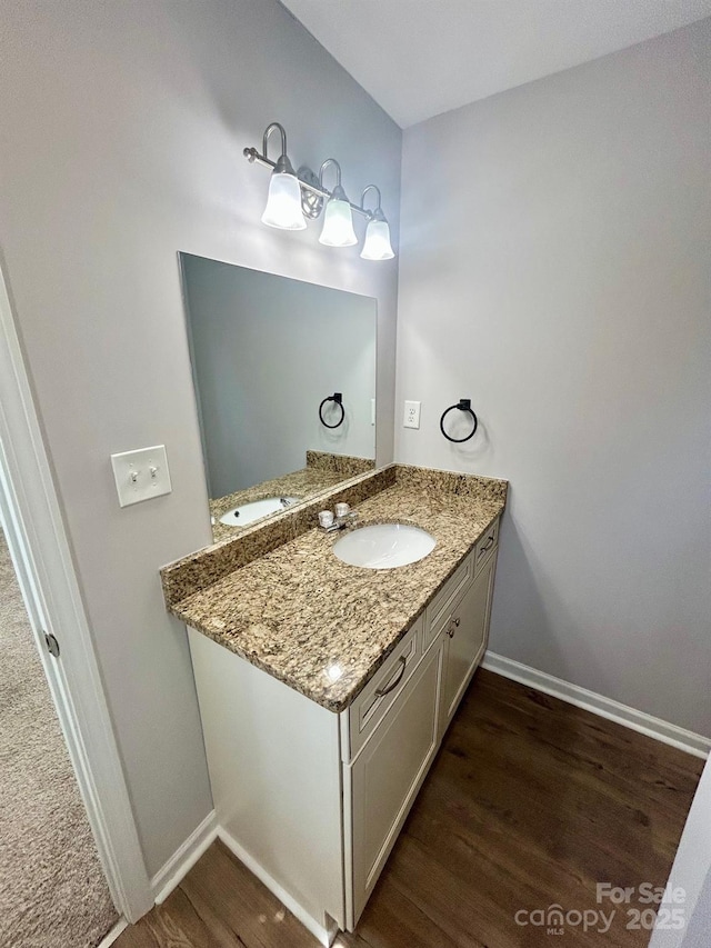 bathroom with baseboards, wood finished floors, and vanity