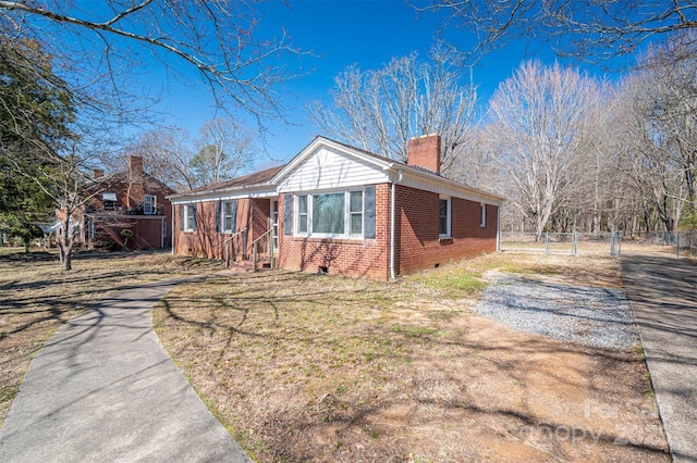 view of front facade featuring driveway, a chimney, crawl space, a front lawn, and brick siding