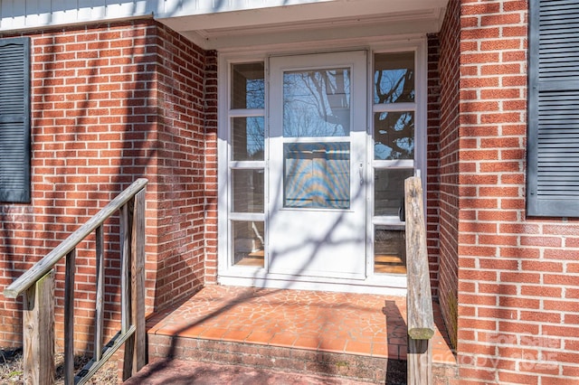 view of exterior entry featuring brick siding