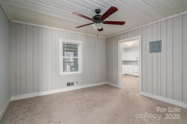 spare room featuring light carpet, ceiling fan, electric panel, and visible vents