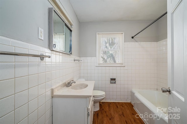 full bathroom featuring tile walls, toilet, vanity, shower / tub combination, and wood finished floors