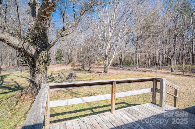 wooden terrace featuring a lawn