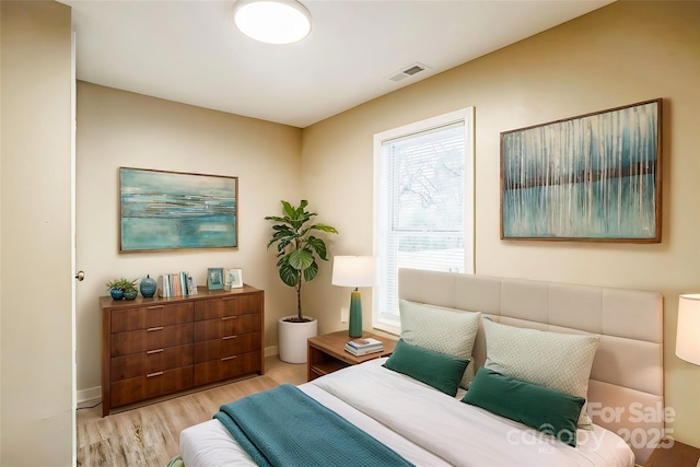 bedroom featuring light wood-style floors, baseboards, and visible vents