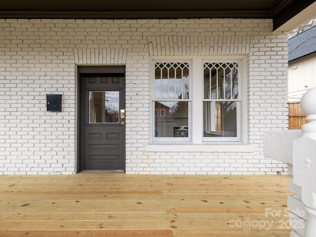 doorway to property featuring brick siding