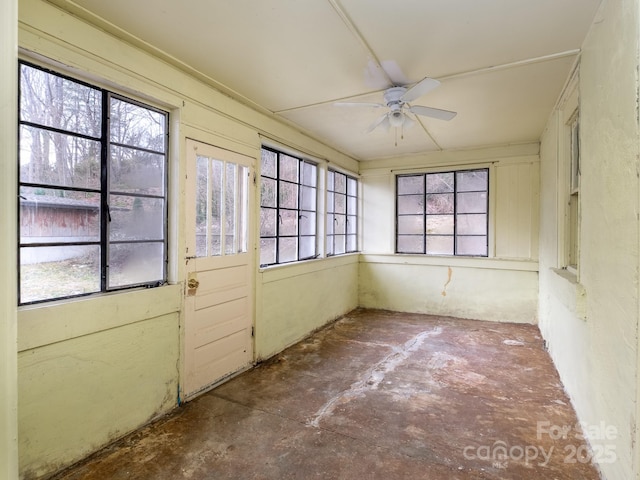 unfurnished sunroom with ceiling fan