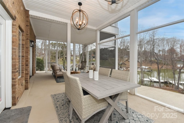 sunroom / solarium featuring a chandelier and a water view