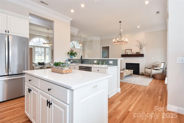 kitchen with open floor plan, appliances with stainless steel finishes, and light wood-style flooring