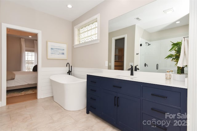 ensuite bathroom with recessed lighting, visible vents, a freestanding bath, a stall shower, and vanity