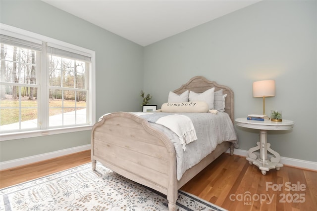 bedroom featuring baseboards and wood finished floors