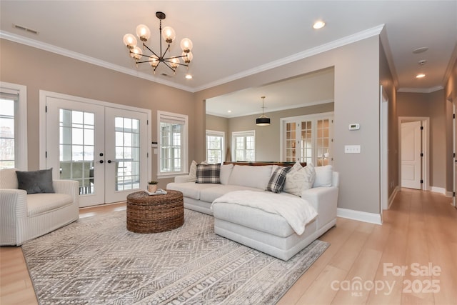 living area with baseboards, french doors, visible vents, and light wood-style floors