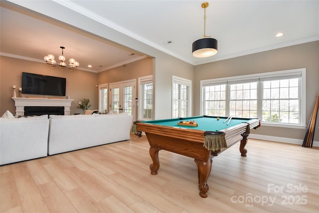 recreation room with light wood-style floors, plenty of natural light, and ornamental molding