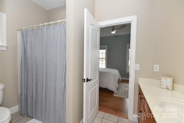 ensuite bathroom featuring toilet, ensuite bathroom, a ceiling fan, vanity, and tile patterned floors