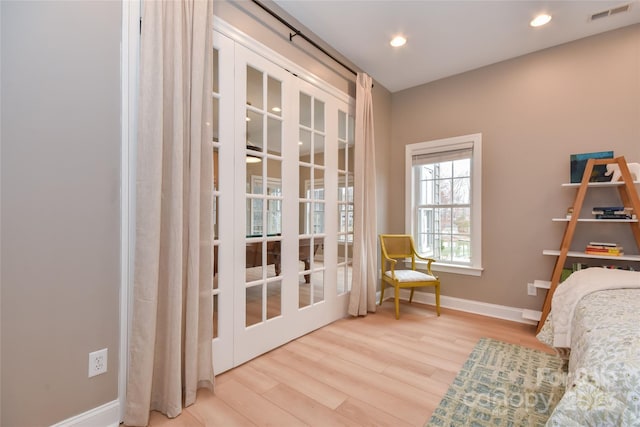 living area with recessed lighting, wood finished floors, visible vents, and baseboards