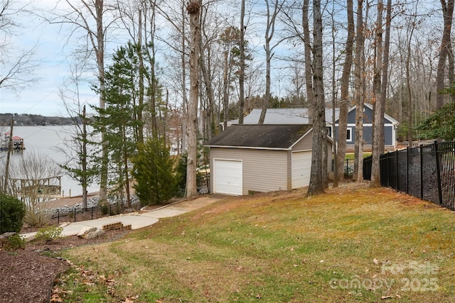 view of yard with a detached garage, fence, and an outdoor structure