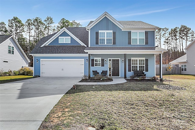 view of front of house featuring a porch, an attached garage, driveway, a front lawn, and board and batten siding