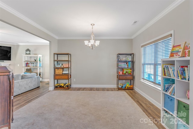 rec room featuring baseboards, light wood-style flooring, ornamental molding, and a notable chandelier