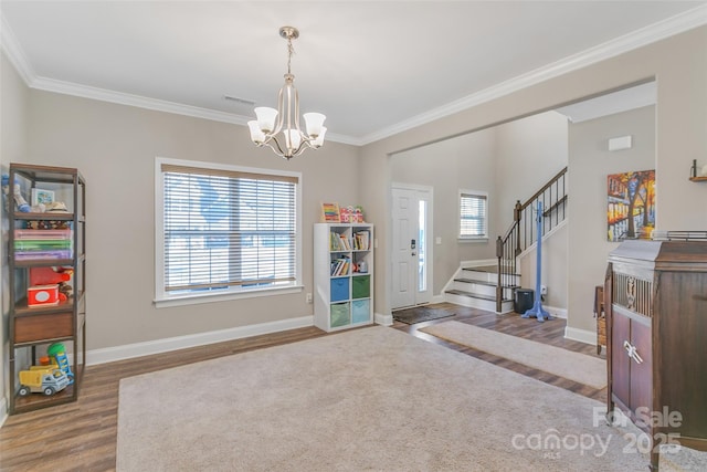 interior space featuring baseboards, stairs, ornamental molding, and wood finished floors