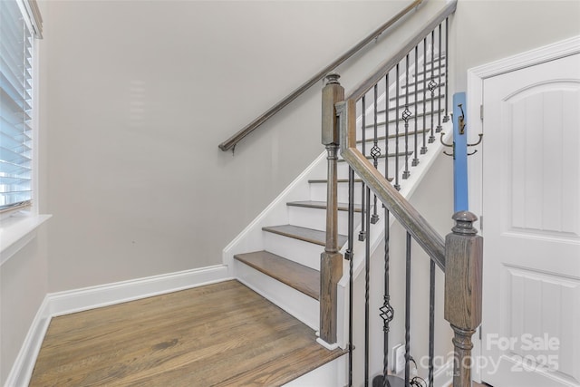 staircase with baseboards and wood finished floors