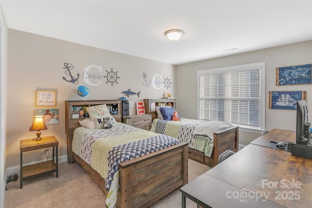 bedroom with light carpet and baseboards