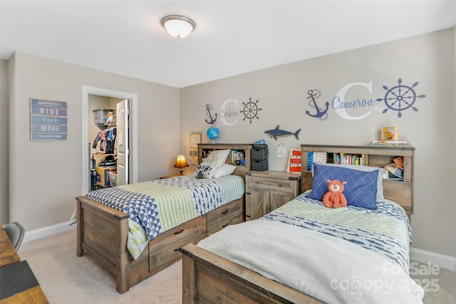 bedroom with light carpet, baseboards, a walk in closet, and a closet