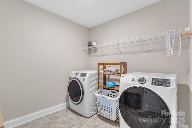 laundry area featuring light carpet, laundry area, washing machine and dryer, and baseboards