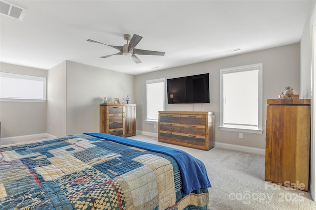 bedroom featuring a ceiling fan, light colored carpet, visible vents, and baseboards