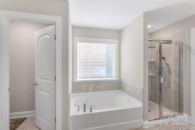 full bathroom featuring tile patterned flooring, a shower stall, and a bath