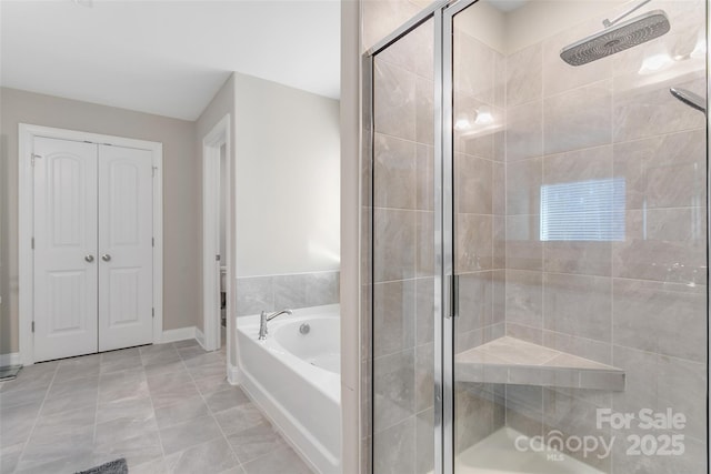 full bath featuring a garden tub, a shower stall, baseboards, and a closet