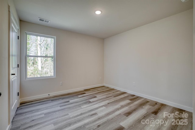 empty room featuring light wood finished floors, baseboards, visible vents, and recessed lighting