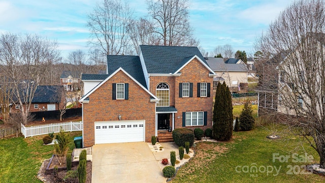 view of front of home with brick siding, concrete driveway, an attached garage, a front yard, and fence