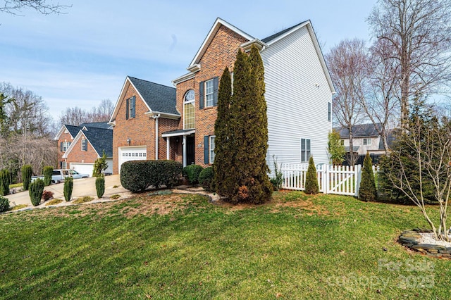 view of side of property featuring driveway, a lawn, an attached garage, fence, and brick siding