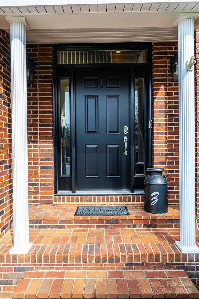 entrance to property featuring brick siding