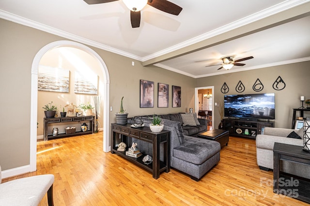 living area with ceiling fan, crown molding, baseboards, and wood finished floors