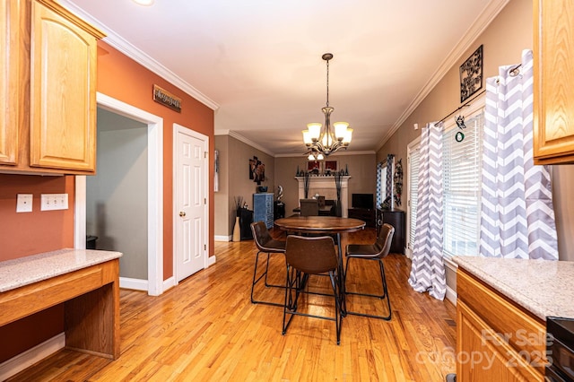 dining space featuring a notable chandelier, crown molding, light wood-style flooring, and baseboards