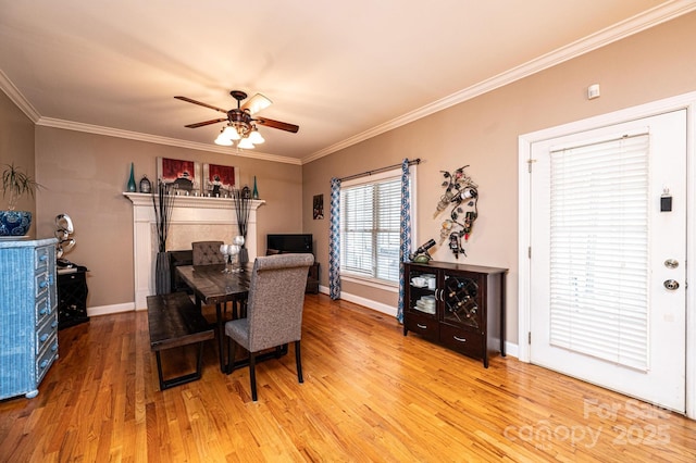 dining area with a ceiling fan, baseboards, ornamental molding, and wood finished floors