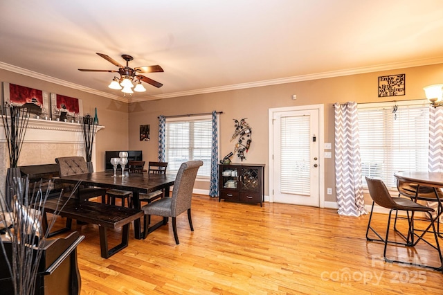 dining room featuring a ceiling fan, baseboards, crown molding, and light wood finished floors