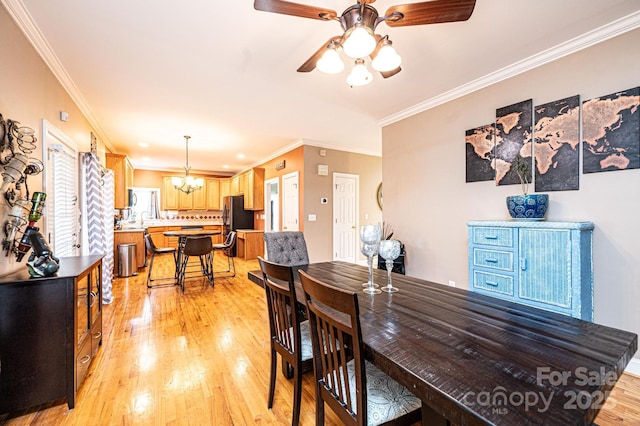 dining area featuring ornamental molding, light wood-type flooring, and ceiling fan with notable chandelier