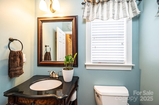 half bath featuring toilet and vanity