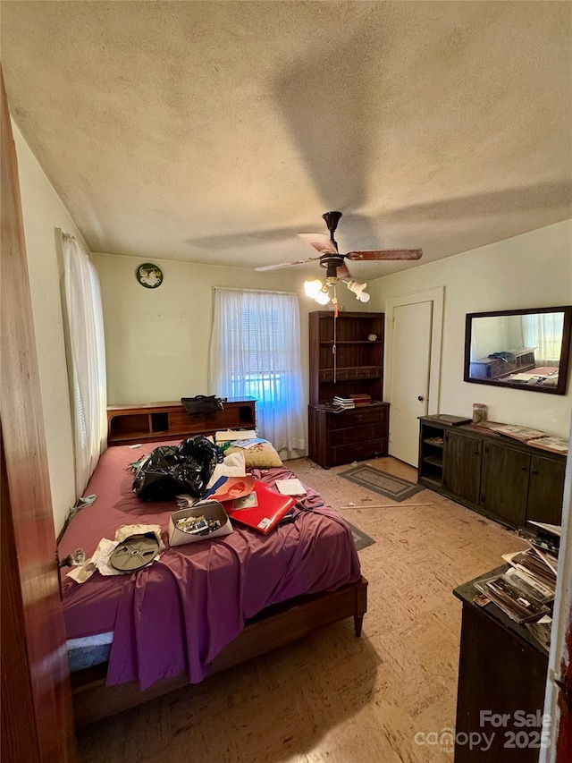 bedroom featuring a ceiling fan and a textured ceiling