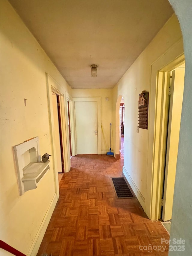 hallway featuring visible vents and arched walkways