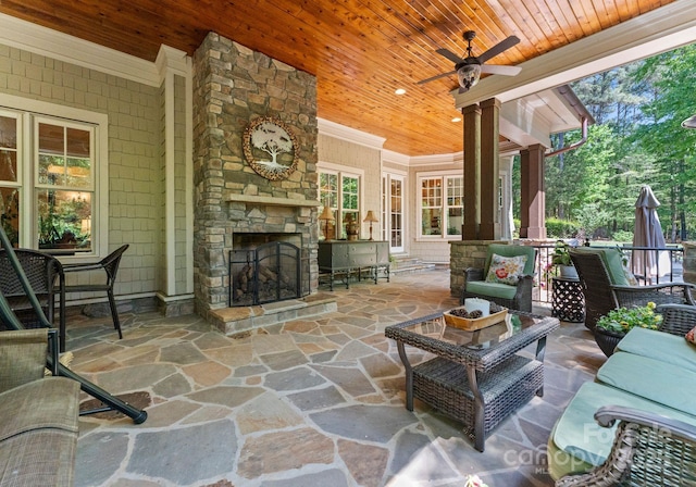 view of patio / terrace with an outdoor living space with a fireplace and ceiling fan
