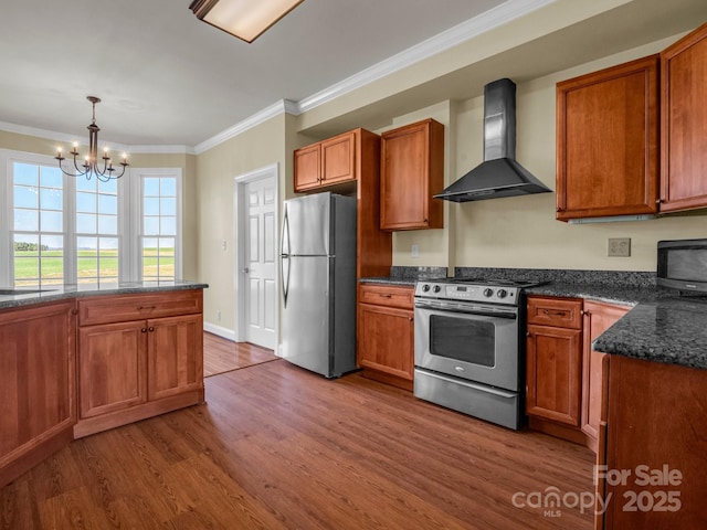 kitchen with crown molding, stainless steel appliances, wood finished floors, wall chimney range hood, and pendant lighting