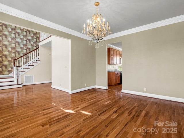 interior space featuring crown molding, visible vents, stairway, wood finished floors, and baseboards