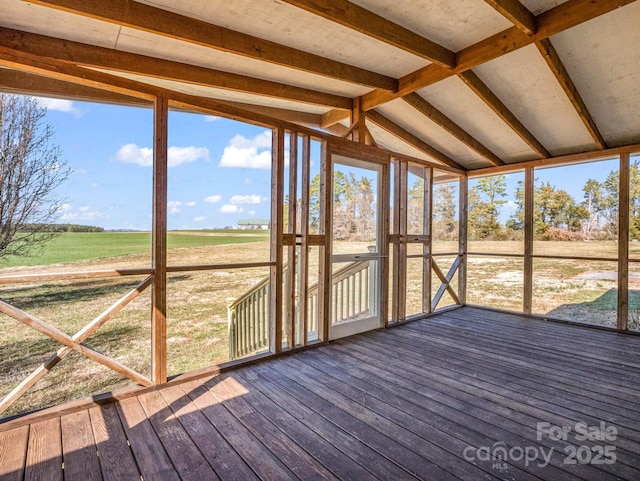 unfurnished sunroom featuring a wealth of natural light, a rural view, and vaulted ceiling