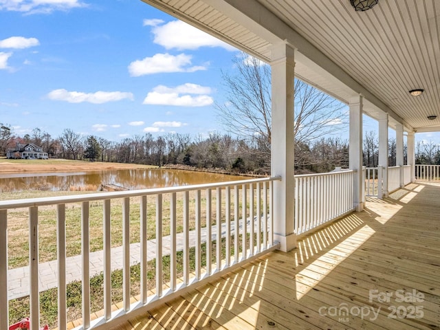 wooden terrace featuring a water view and covered porch