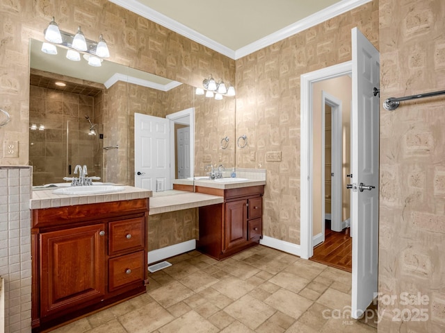 bathroom with crown molding, a sink, a shower stall, and baseboards