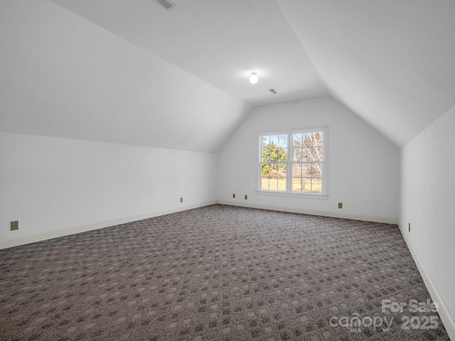 bonus room featuring visible vents, baseboards, vaulted ceiling, and dark colored carpet