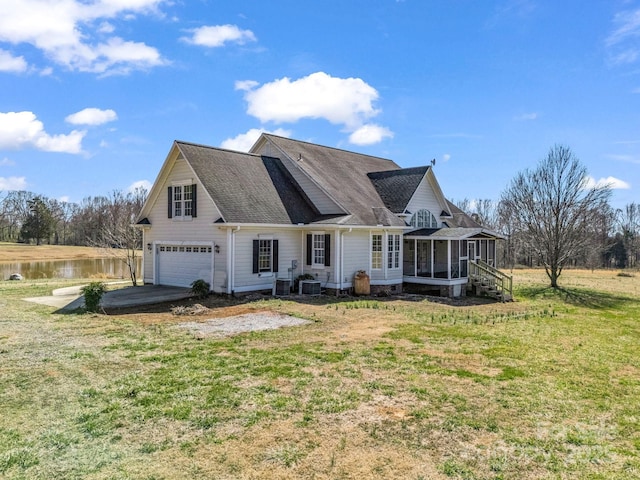 rear view of house featuring a yard, a water view, an attached garage, central AC unit, and a sunroom