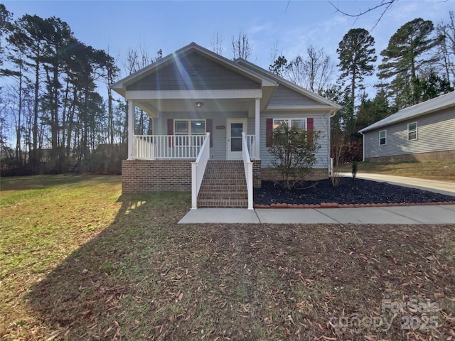 bungalow with covered porch, a front yard, and stairs